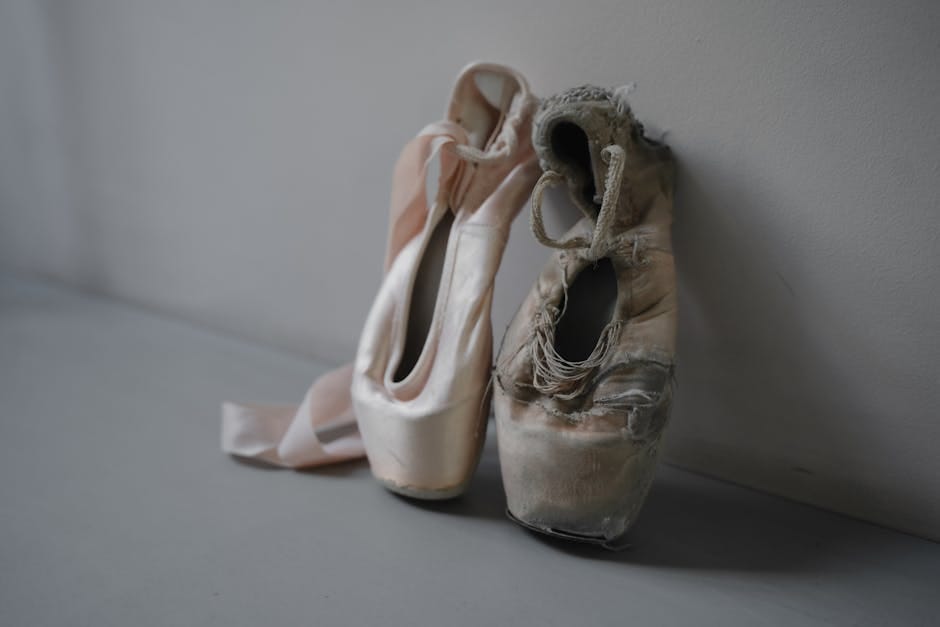 A close-up of a new and worn ballet pointe shoes symbolizing the journey of a dancer.