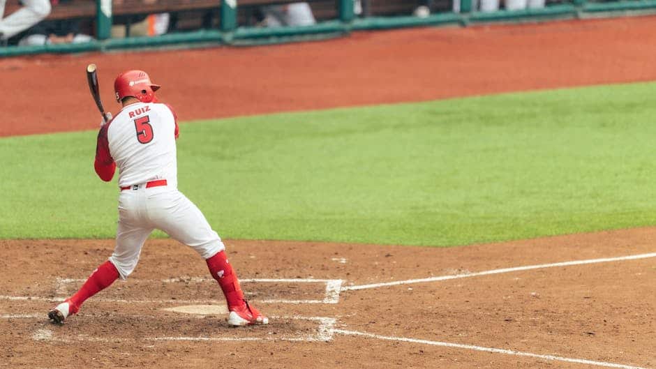Action shot of a baseball player swinging a bat in a game with clear view of field.