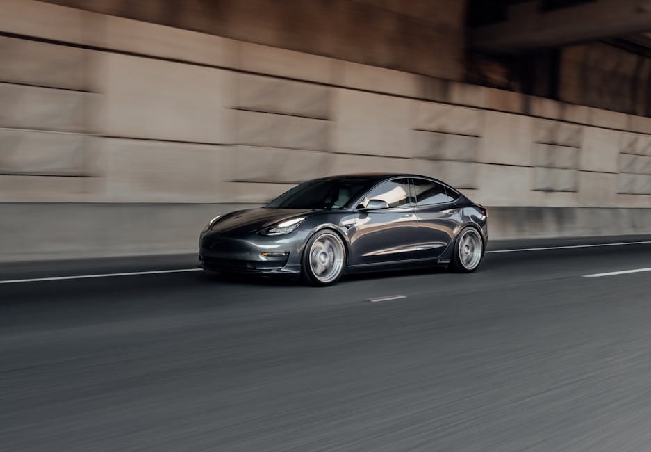 Dynamic view of a luxury electric car speeding on a highway, showcasing motion blur.