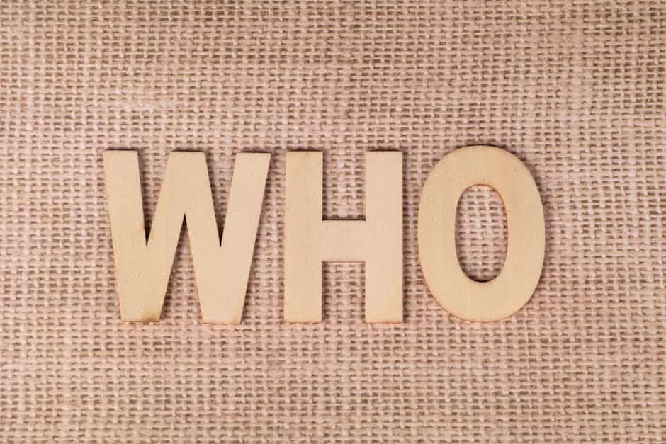 Wooden letters spelling 'WHO' on a textured burlap fabric, emphasizing identity or inquiry.