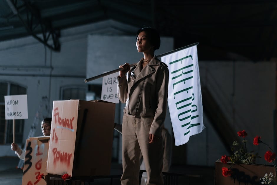 Young woman leads a peaceful protest holding a freedom banner indoors.