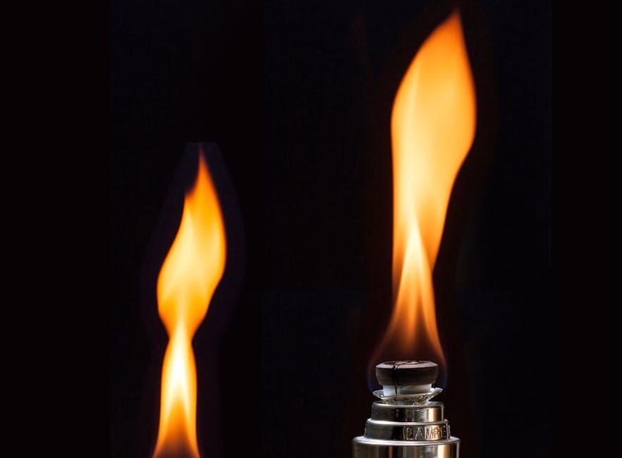 A detailed shot of a bright flame from a lighter against a dark backdrop. Captures the essence of heat and light.