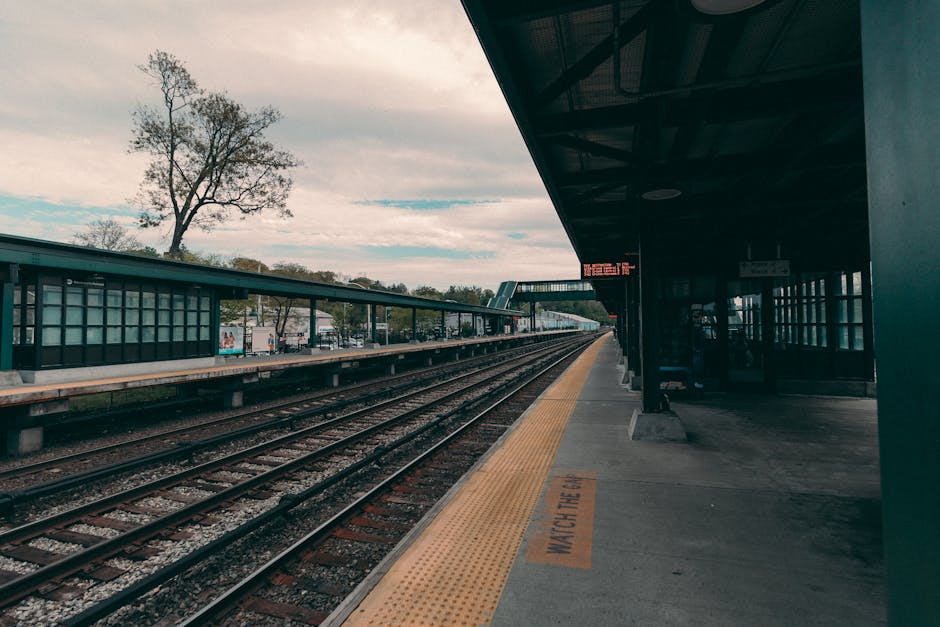 A serene view of an empty train station platform in Tarrytown, New York under a cloudy sky.