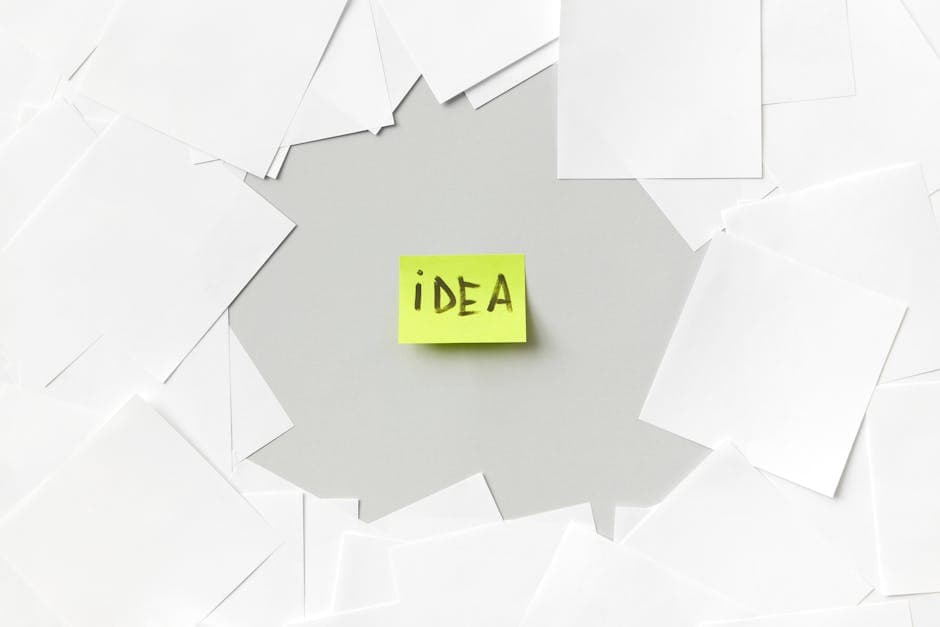 Yellow sticky note labeled 'Idea' surrounded by white papers, symbolizing creativity.