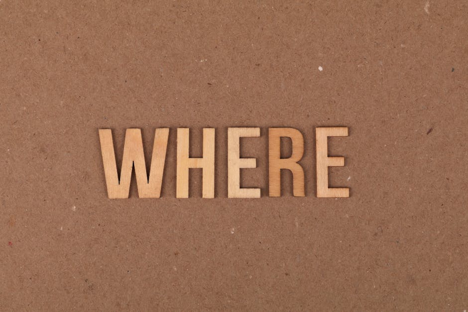 Wooden letters spelling 'WHERE' on a brown cardboard background.