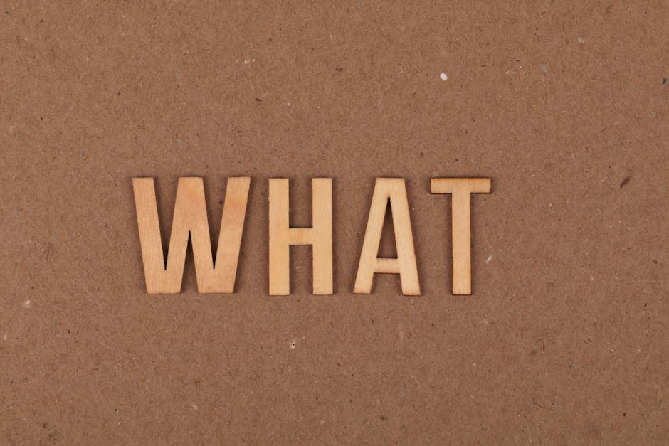 Wooden letters spelling 'What' on a brown cardboard background, close-up view.