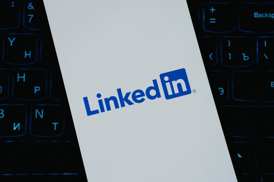 Close-up of LinkedIn logo on smartphone screen, with keyboard background.