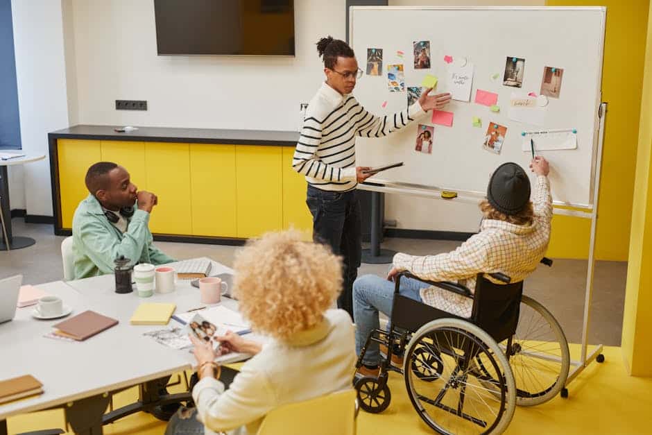 A diverse group of professionals in a creative workspace discussing ideas and planning on a whiteboard.