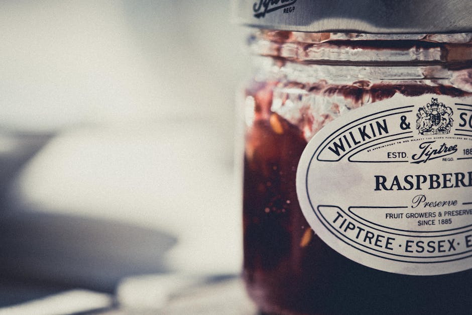 Artistic shot of a Tiptree raspberry preserve jar with vintage label.