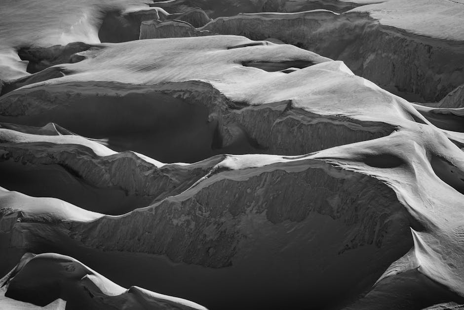 Captivating black and white photo of Saas Fee's snowy mountain formations.