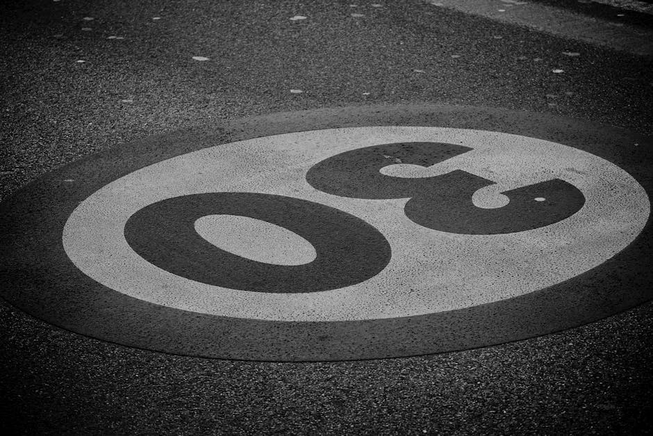 A black and white image of a 30 speed limit sign painted on a road in Tuscany, Italy.